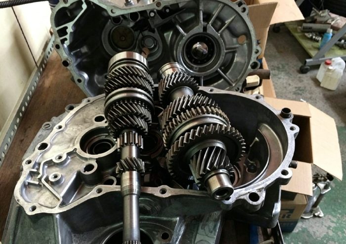 Mechanic inspecting Shacman gearbox shift components and checking lubricant levels