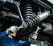 Mechanic inspecting Sinotruk Sitrak chassis bolts and shock absorbers (genuine parts)